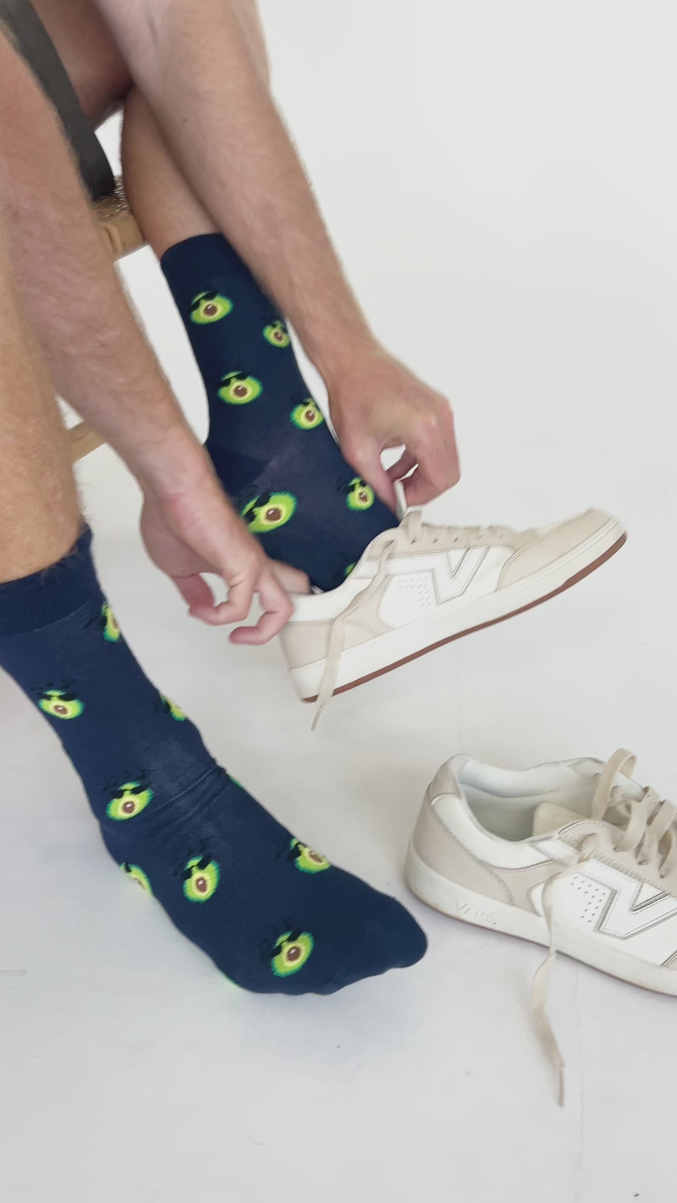Video of man putting on avocado print bamboo socks with white sneakers. Breathable and fun socks for everyday wear or gifting.