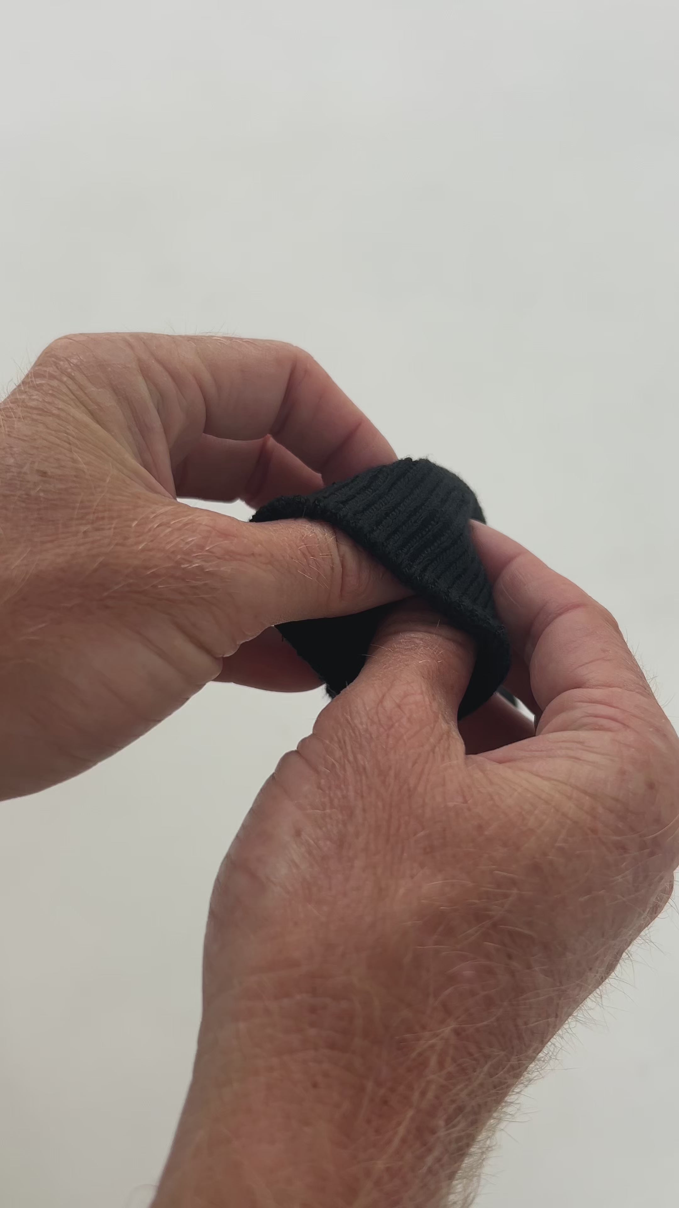 Video showing hands stretching thick men's black bamboo winter sock, highlighting softness, warmth, and elasticity