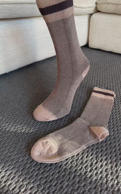 Video showing close-up zoom of brown ribbed bamboo and cotton crew socks with contrast heel and toe to highlight fabric texture